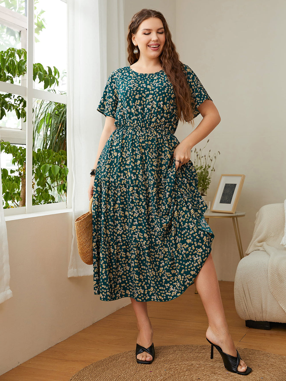 Floral Midi Dress – Plus Size round neck short sleeve, A-line silhouette with flutter sleeves, worn by a smiling woman in cozy setting.