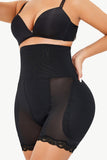 Woman wearing black Lace Trim Shaping Shorts with lace detailing, designed for comfort and seamless layering under outfits.