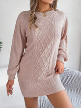 Woman wearing a diamond cable knit sweater dress with long sleeves, featuring a cable-knit and ribbed design.