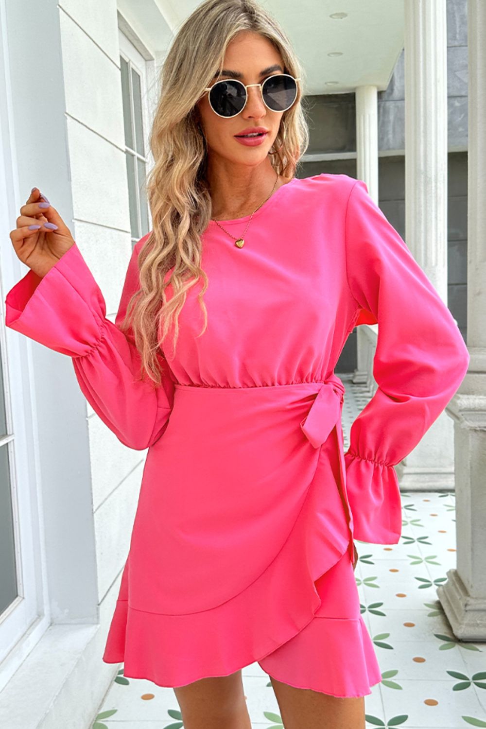 Woman wearing Ruffle Hem Mini Dress with shiny flounce sleeves, showcasing elegant style.
