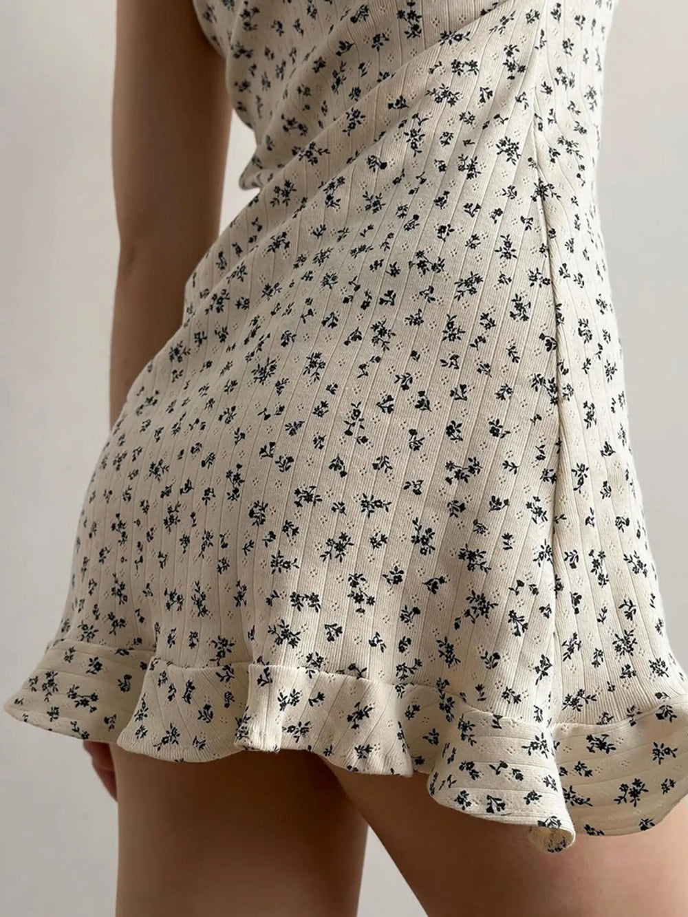 Close-up of Floral Print Lounge Dress with ruffle hem and delicate floral pattern in beige.