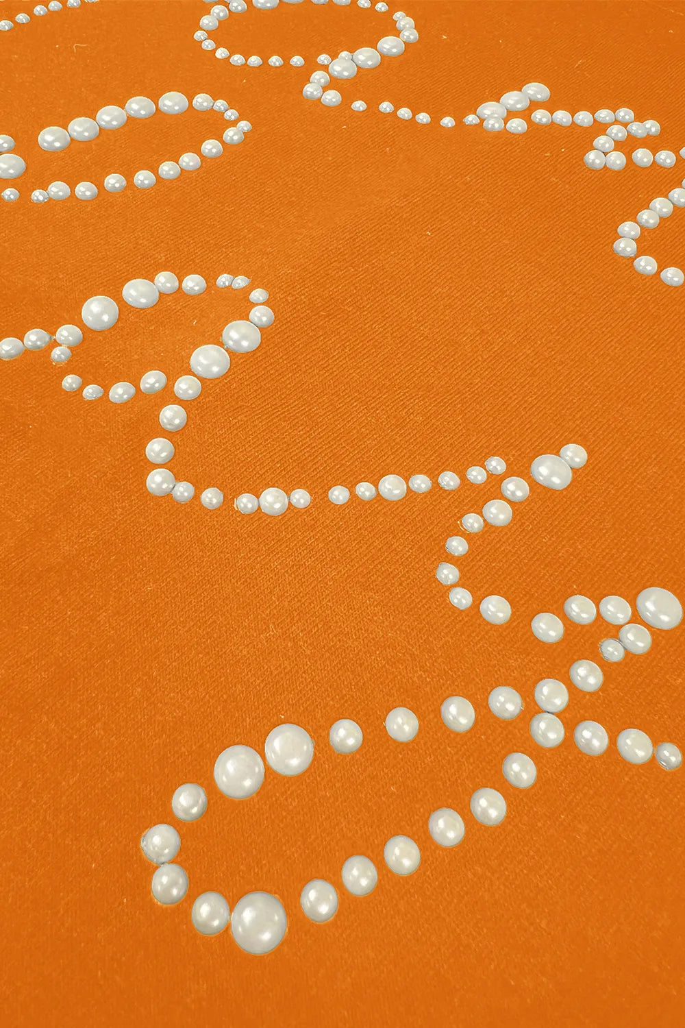 Orange fabric of Game Day Sweatshirt with pearl-like embellishments on surface, showcasing style details for cozy casual wear.