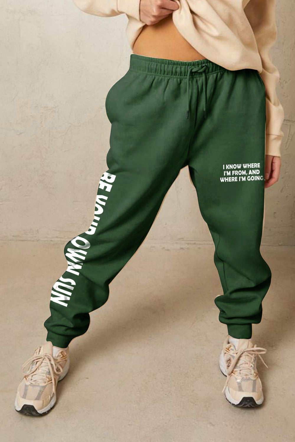 Green Graphic Sweatpants with "BE YOUR OWN SUN" print and adjustable waistband for stylish comfort.
