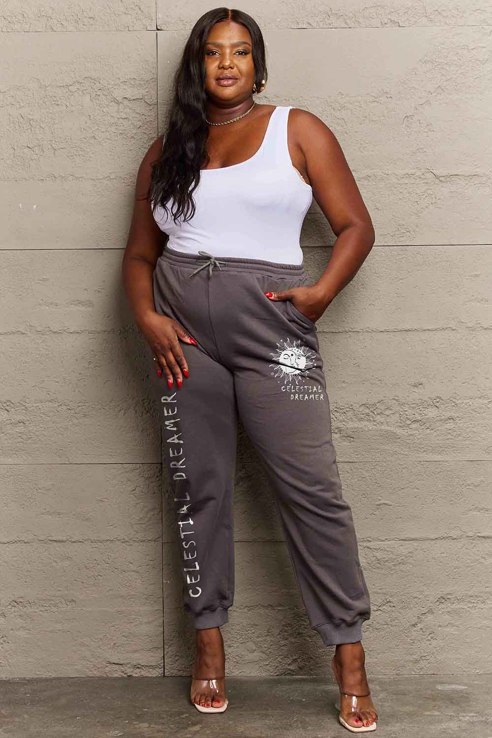 Model wearing Graphic Sweatpants with "CELESTIAL DREAMER" print, showcasing relaxed style and comfort for everyday wear.