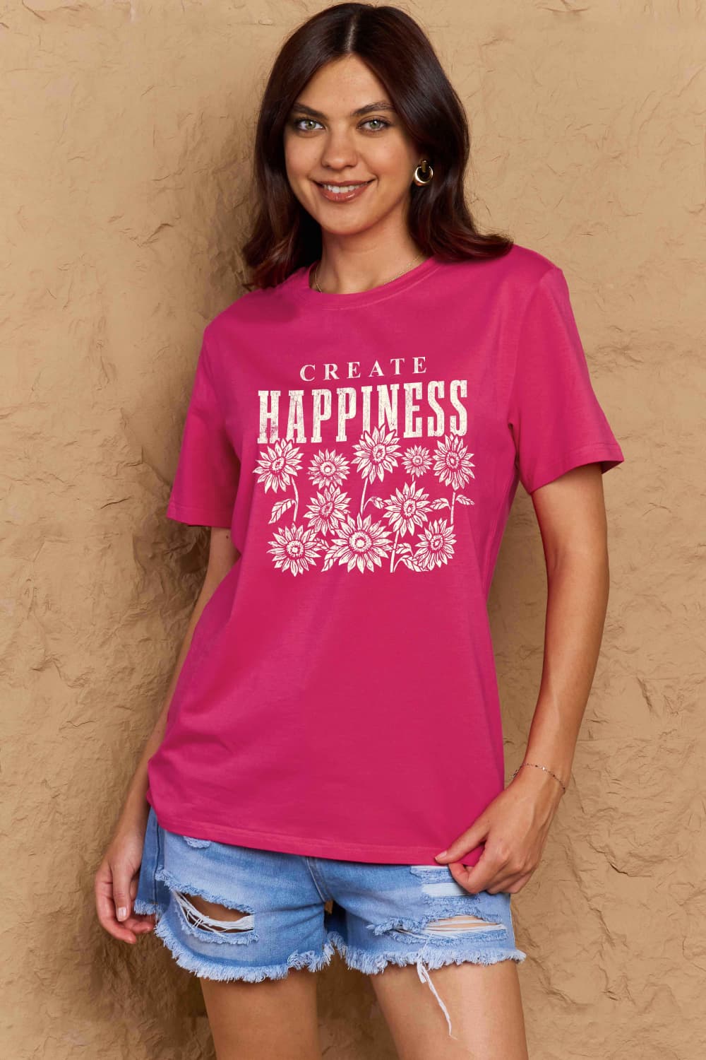 Woman wearing Graphic Cotton T-Shirt with CREATE HAPPINESS print, vibrant pink color, perfect for casual and uplifting style.