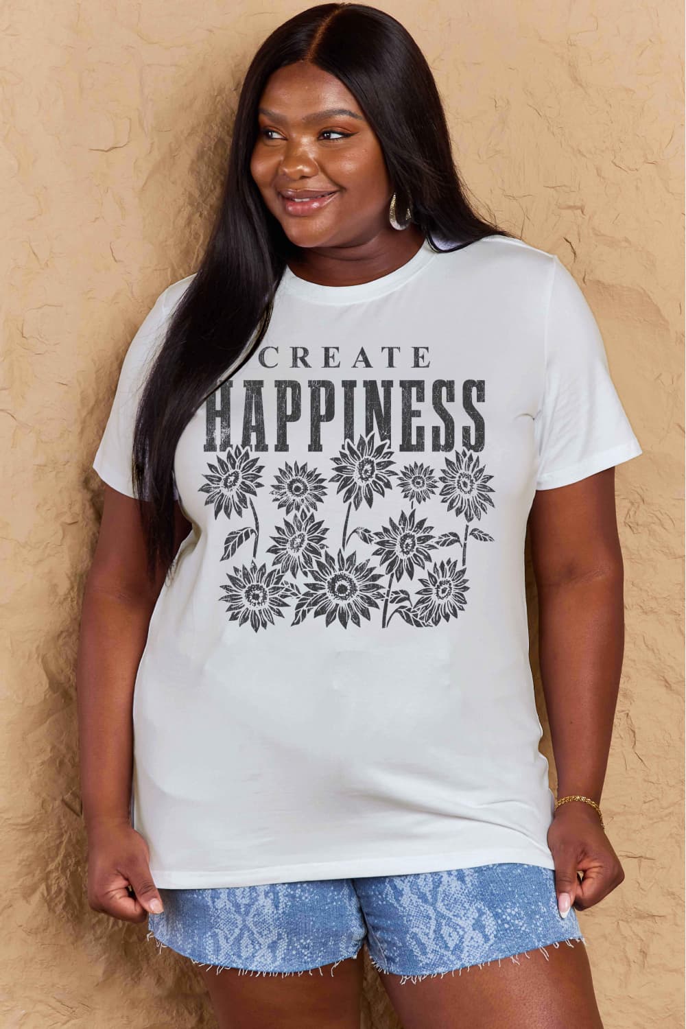 Woman wearing Graphic Cotton T-Shirt with 'CREATE HAPPINESS' print and floral design, showcasing casual style and comfort.