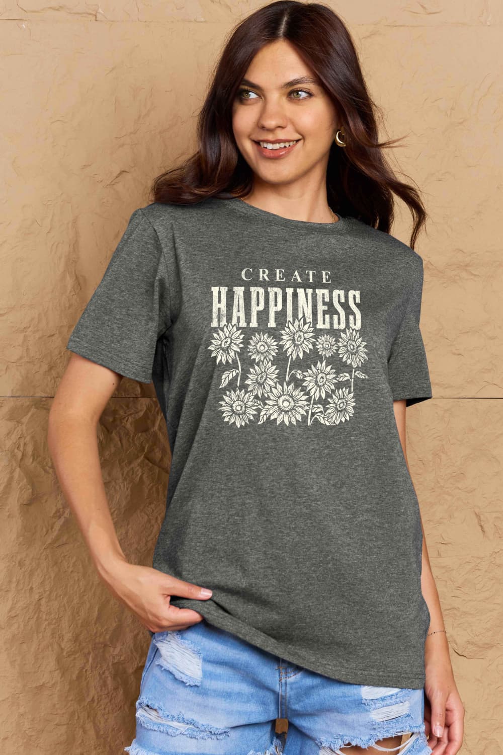 Woman wearing Graphic Cotton T-Shirt with 'CREATE HAPPINESS' print, showcasing casual style and positive vibes.