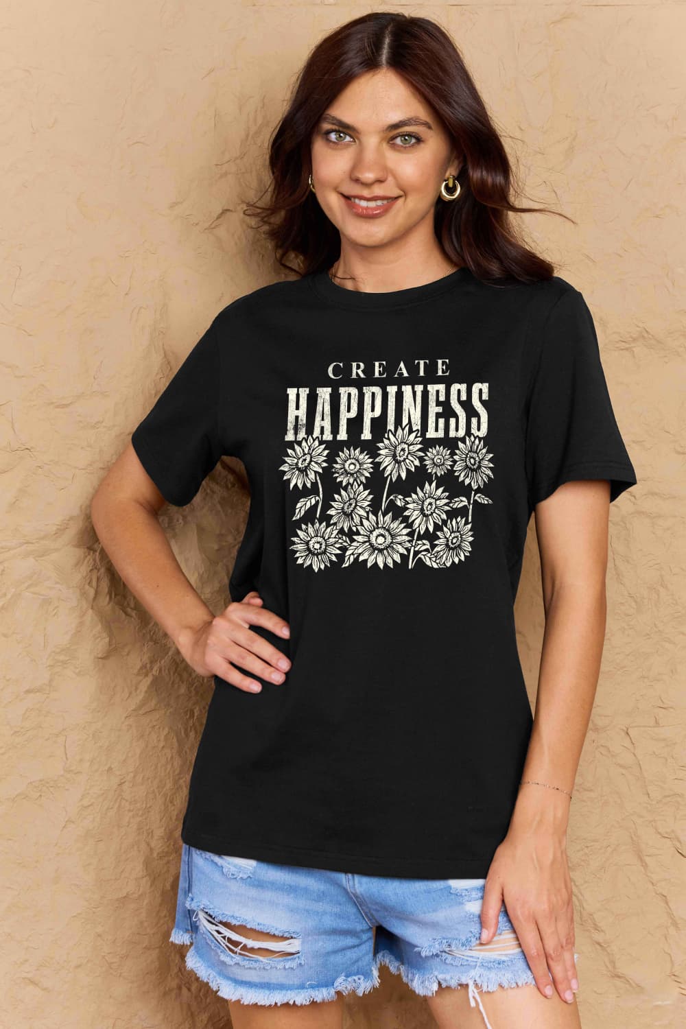 Woman wearing Graphic Cotton T-Shirt with 'CREATE HAPPINESS' print, emphasizing a casual and uplifting style.