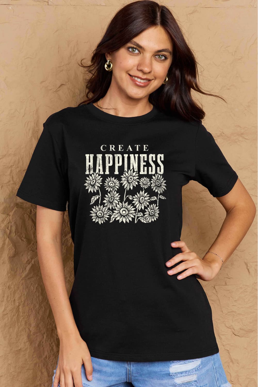 Woman wearing Graphic Cotton T-Shirt with 'CREATE HAPPINESS' print, enhancing casual style.