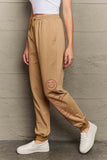 Model wearing Graphic Sweatpants with emoji print, featuring a relaxed fit and drawstring waist for comfortable casual style.