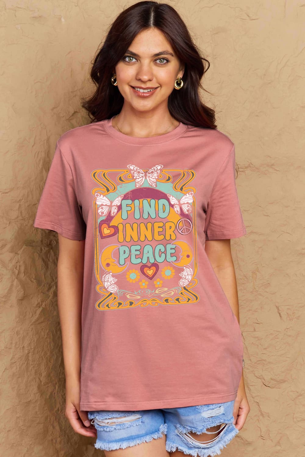 Woman wearing Graphic Cotton T-Shirt with 'FIND INNER PEACE' print, styled casually with denim shorts.