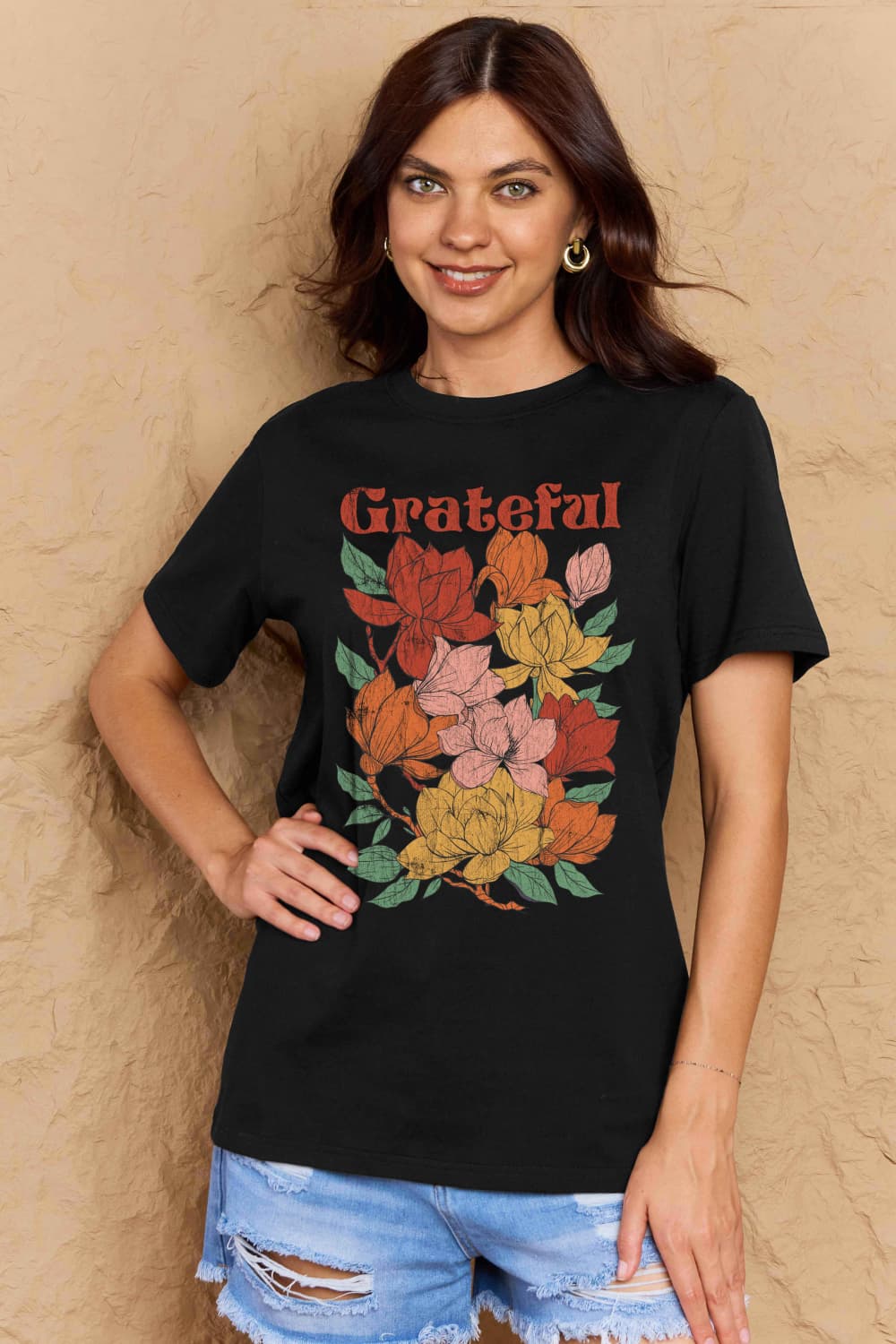 Woman wearing Graphic Cotton T-Shirt with 'GRATEFUL' flower print, casual outfit for positive vibes and inclusive fit