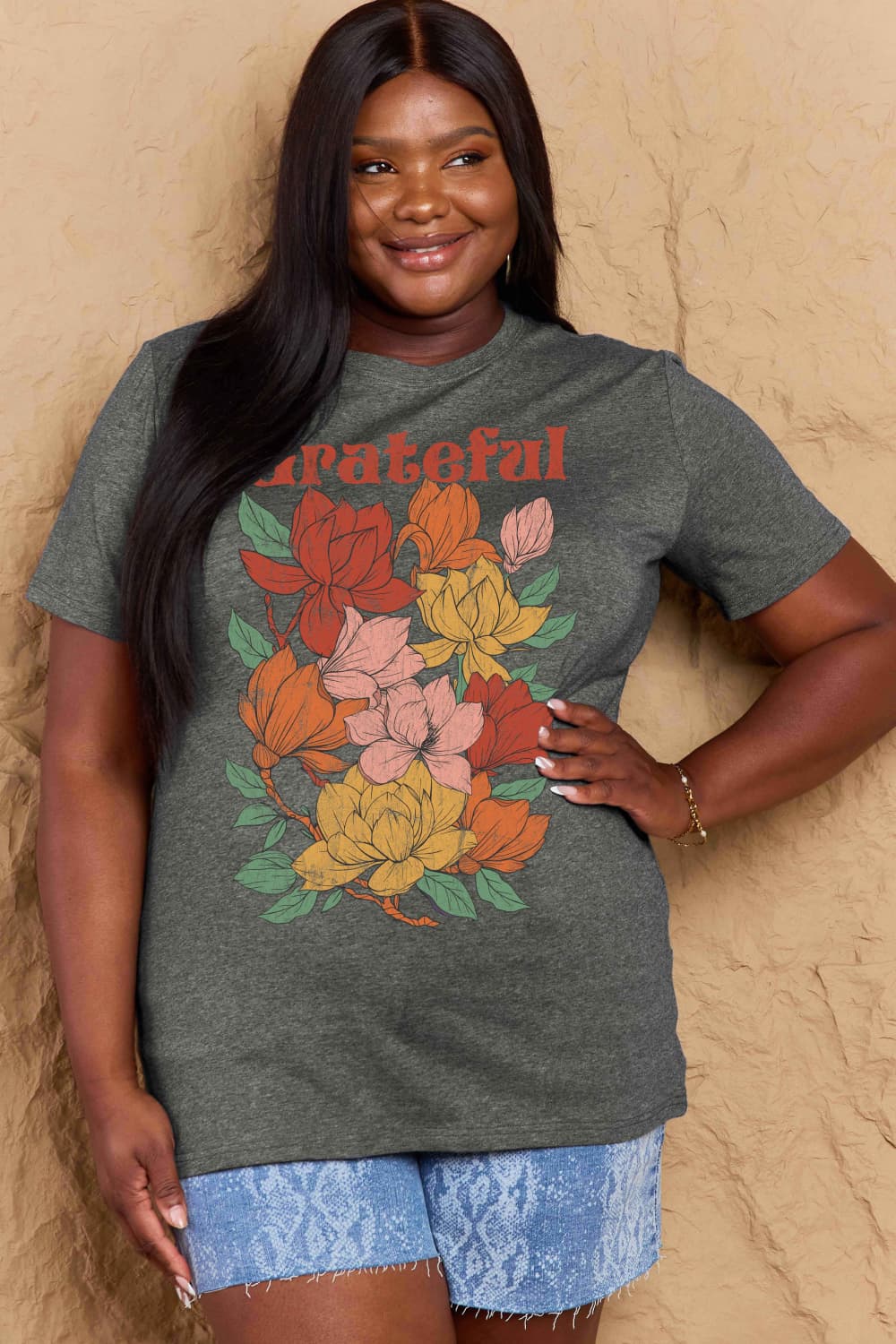 Woman wearing Graphic Cotton T-Shirt with GRATEFUL flower print, showcasing plus size fit.