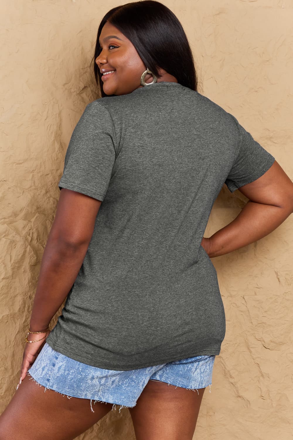 Back view of woman wearing Graphic Cotton T-Shirt in gray with denim shorts