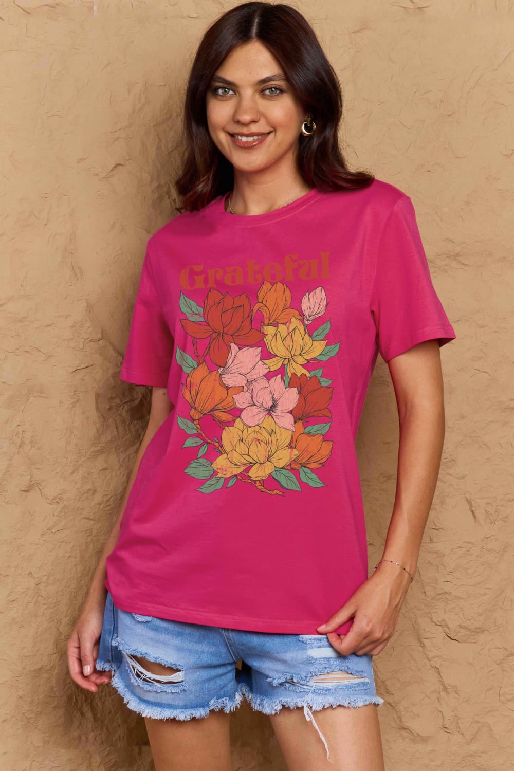 Woman wearing Graphic Cotton T-Shirt with 'GRATEFUL' flower print, embodying positive vibes and inclusivity in casual fashion.