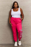 Woman wearing Graphic Sweatpants with PINK print, featuring drawstring waistband, ideal for casual wear and style.