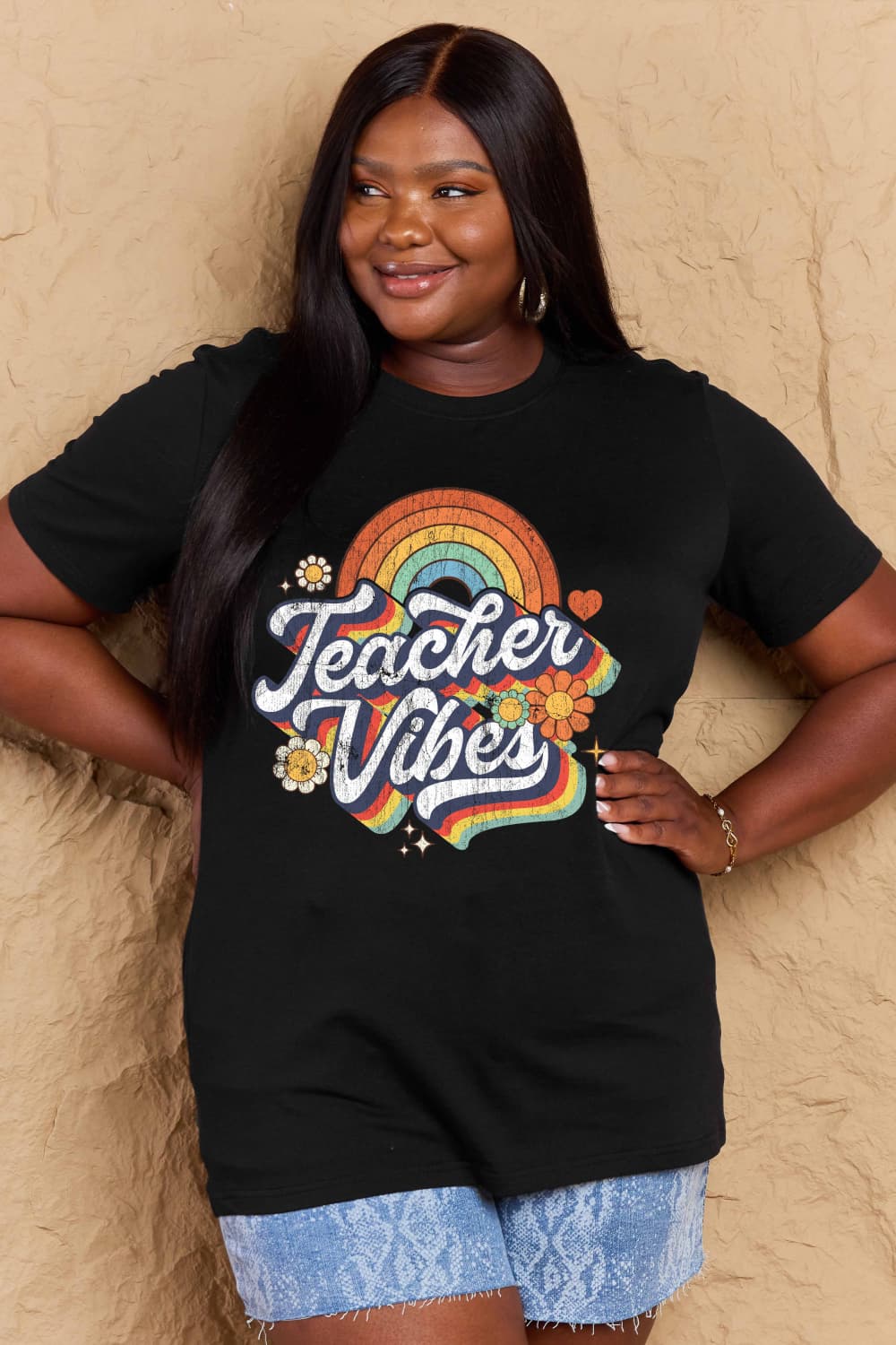 Smiling individual wearing a black Graphic Cotton T-Shirt with 'TEACHER VIBES' print, casual and expressive clothing for teachers.