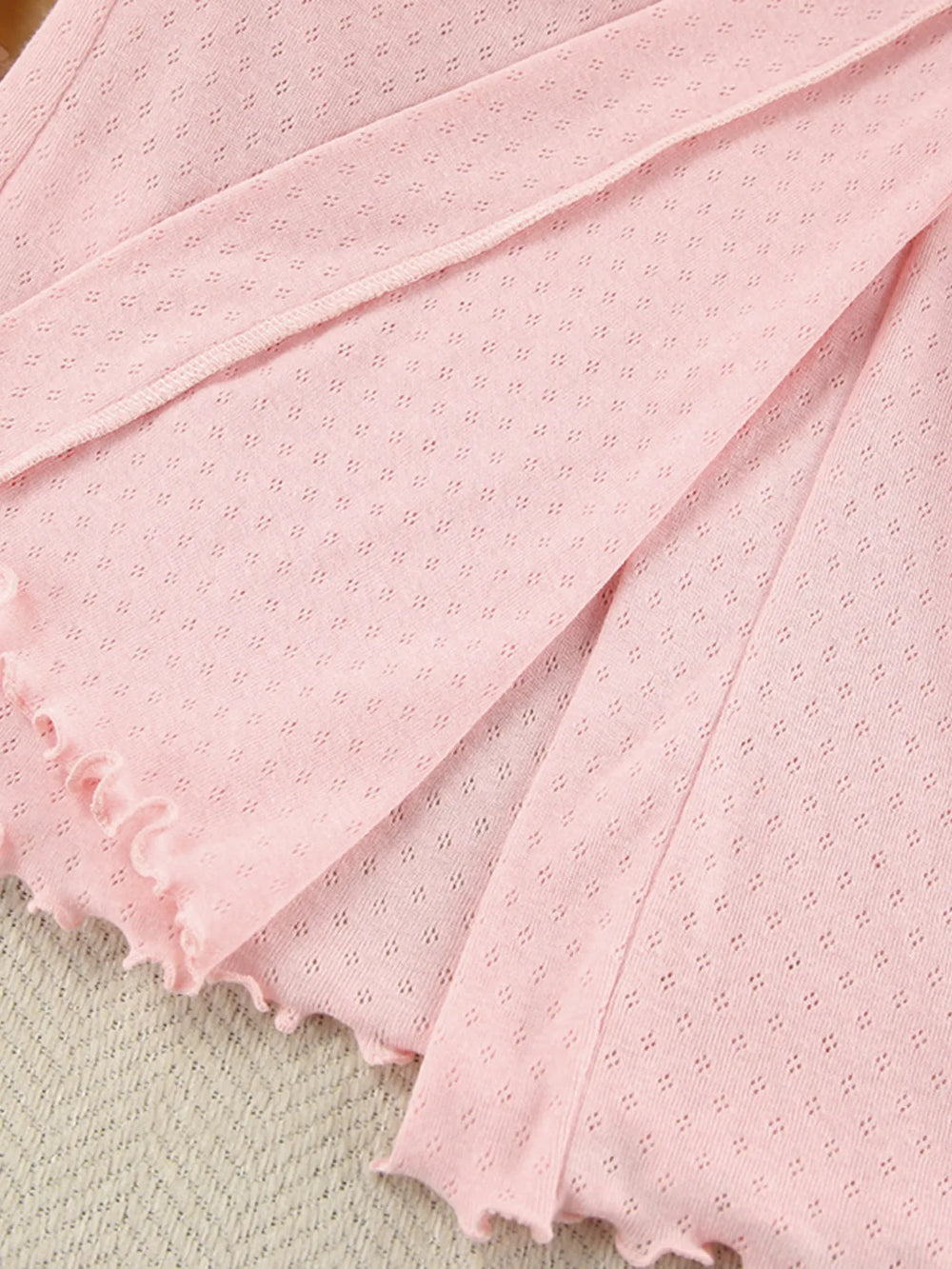 Close-up of pink Tie Waist Lounge Nightgown fabric with delicate texture and frayed edges.