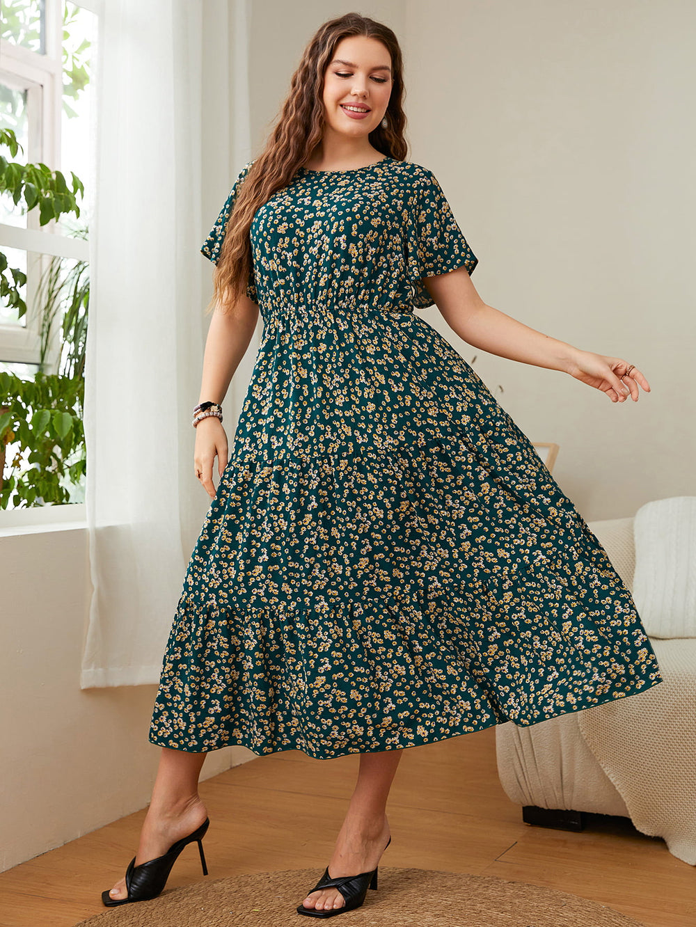 Woman wearing Floral Midi Dress, plus size round neck short sleeve, with flutter sleeves and A-line silhouette in a stylish room.