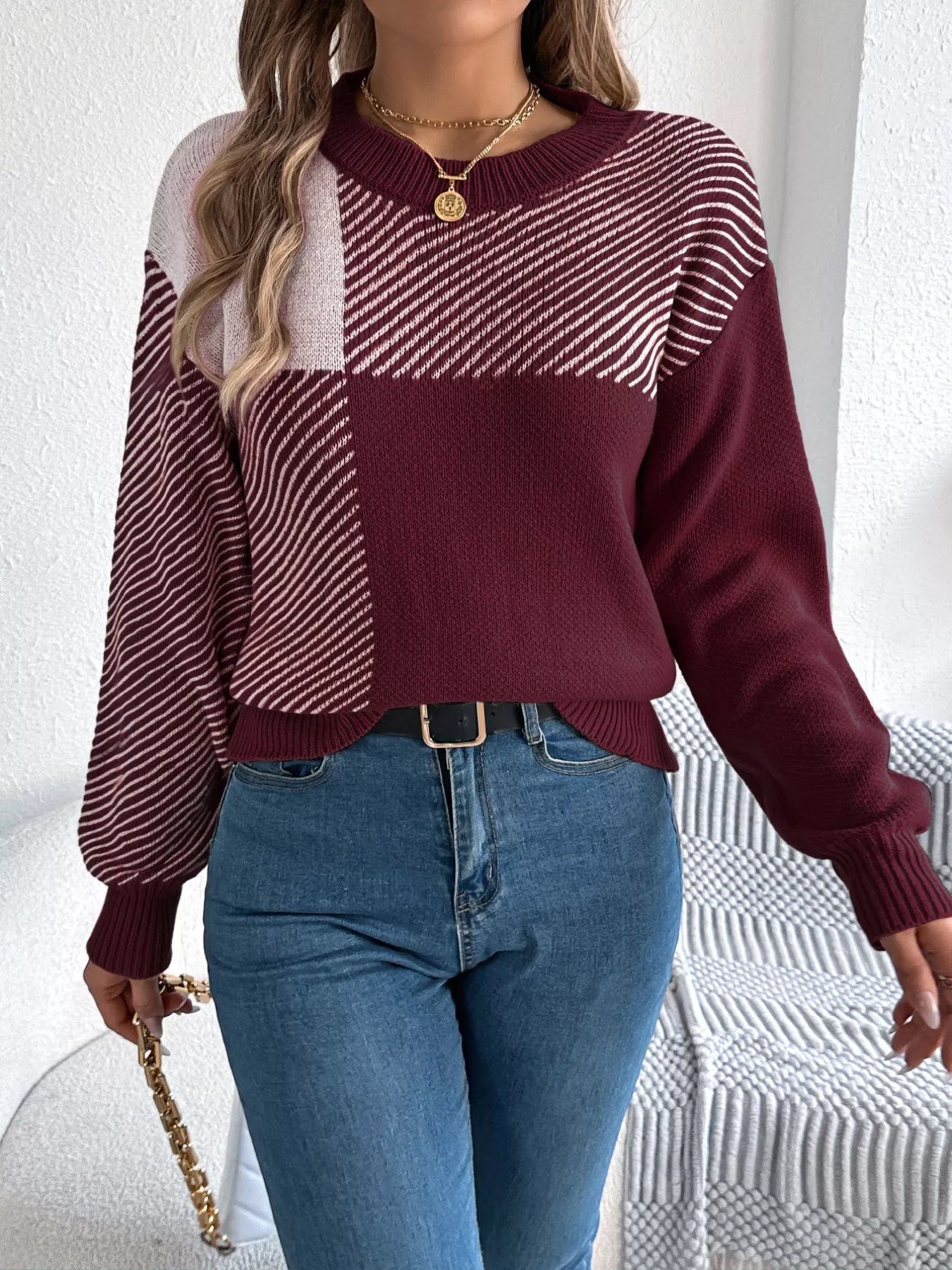 Woman wearing Color Block Striped Sweater with round neck and bold pattern, showcasing contemporary style and cozy sophistication.