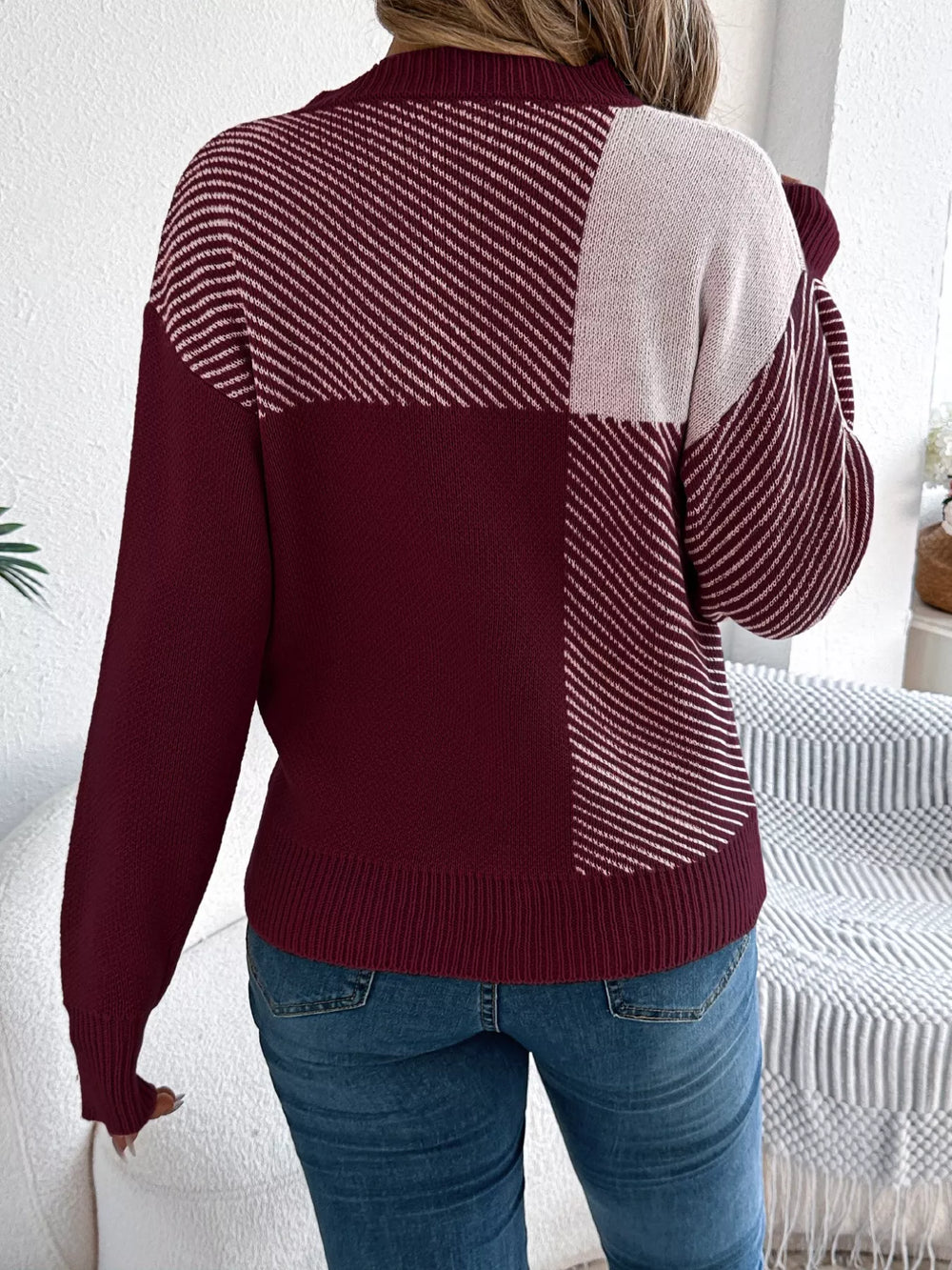 Woman wearing Color Block Striped Sweater with round neck and bold color block striped pattern, viewed from the back.