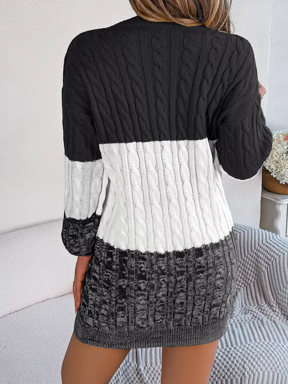 Back view of color block cable knit sweater dress with textured pattern in black, white, and grey colors.